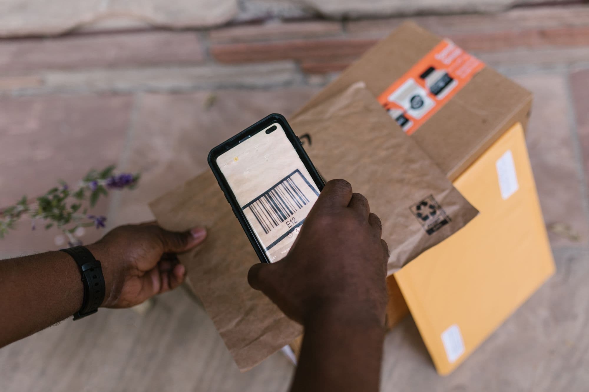Hands scanning a parcel barcode with a phone